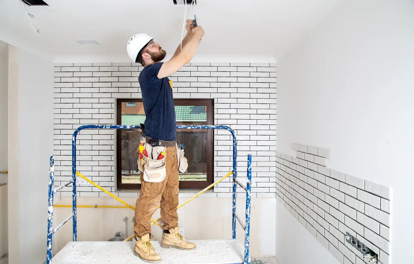 A professional in overalls with tools against the backdrop of a repair site. Home renovation concept.